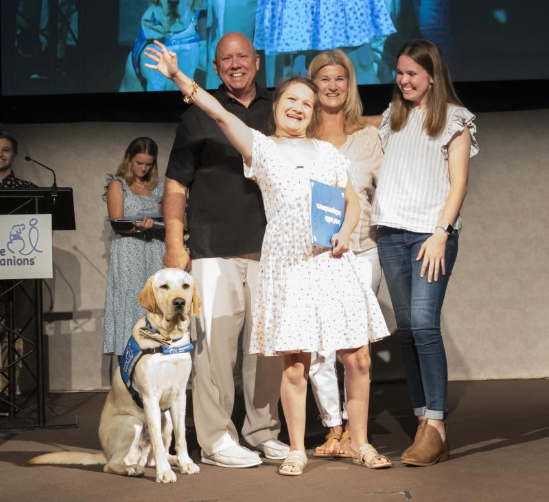 Jazmin Tinsley smiles and waves after receiving the leash of her service dog, Bonus, during the August graduation ceremony at Canine Companions in Medford, N.Y., with (l-r) her parents Kevin and Sandy Tinsley, and volunteer puppy raiser and instructor Leah Thye. SUBMITTED PHOTO